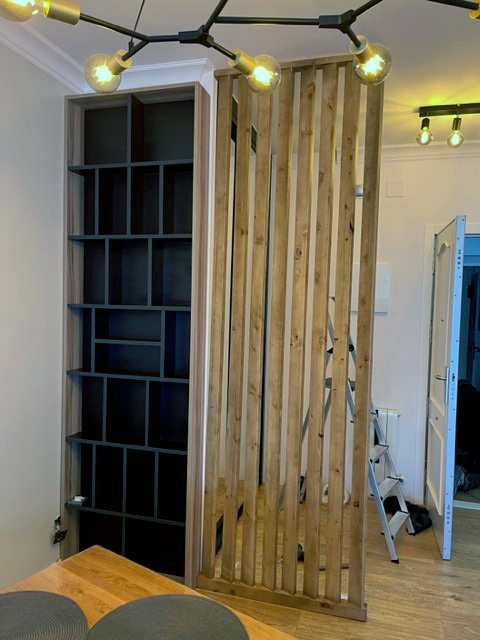 mueble a medida en Barcelona, pared de listones en madera y estantería negra